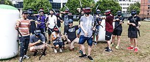A birthday group playing Arrow Tag with bows on the grass